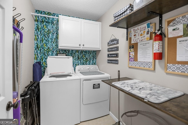 laundry area with a textured ceiling, cabinet space, and washing machine and clothes dryer