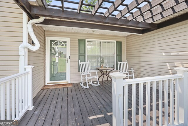 deck featuring covered porch and a pergola