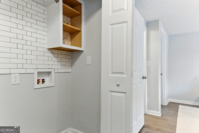 laundry room with baseboards, wood finished floors, and hookup for a washing machine