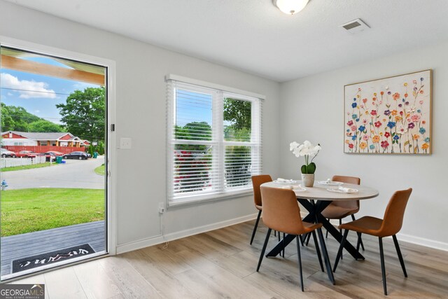 dining space featuring visible vents, wood finished floors, and a healthy amount of sunlight