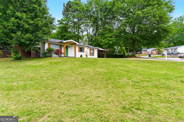 ranch-style house with a front lawn and fence