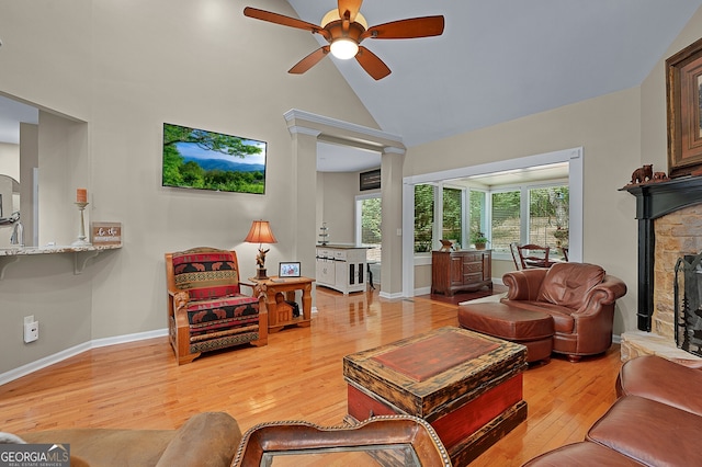 living room with light wood finished floors, ceiling fan, a wealth of natural light, and high vaulted ceiling