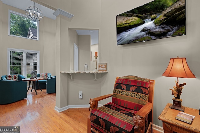 sitting room featuring a chandelier, hardwood / wood-style flooring, and baseboards