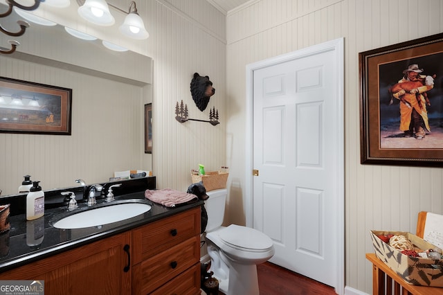 bathroom with wood finished floors, toilet, and vanity