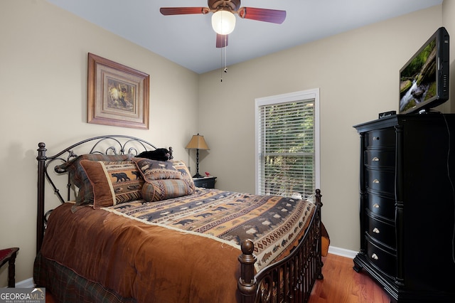 bedroom featuring ceiling fan, baseboards, and wood finished floors