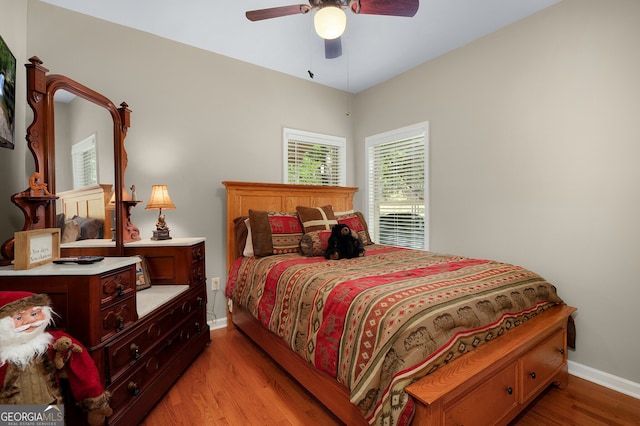 bedroom featuring baseboards, light wood-type flooring, and ceiling fan