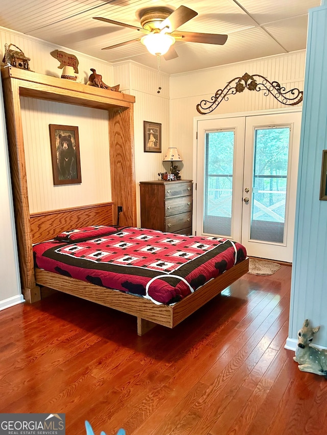 bedroom featuring wood walls, wood finished floors, access to exterior, french doors, and crown molding