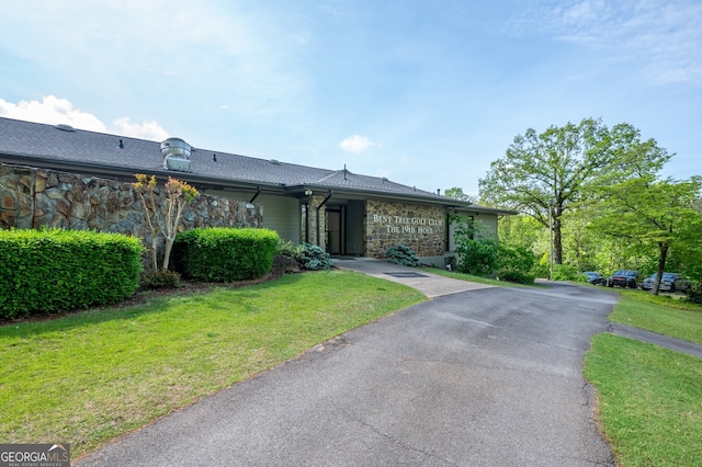 view of front of house featuring stone siding and a front lawn