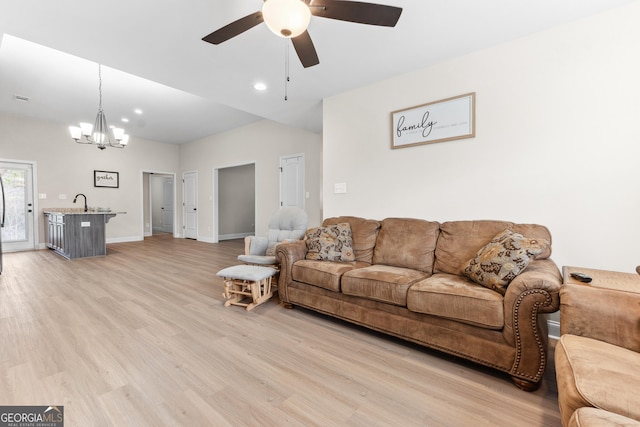 living area with ceiling fan with notable chandelier, light wood-style flooring, baseboards, visible vents, and recessed lighting
