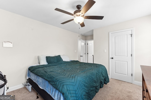 bedroom featuring light carpet, a ceiling fan, and baseboards