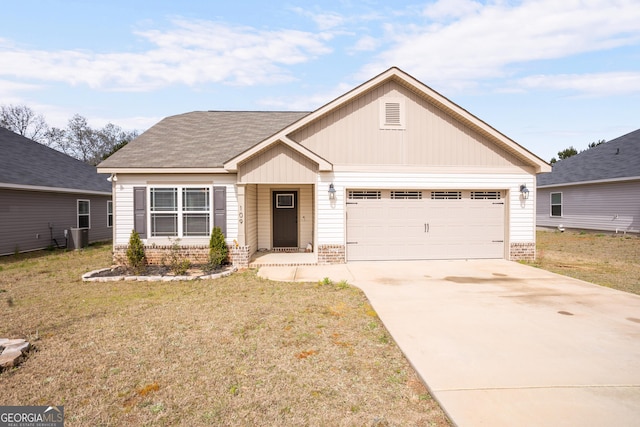 view of front of home with an attached garage, a front lawn, driveway, and brick siding