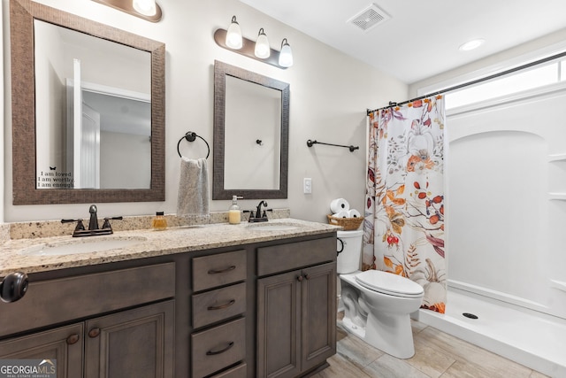 full bathroom featuring visible vents, a sink, a shower with shower curtain, and toilet