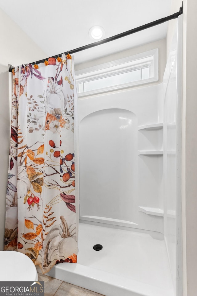 full bathroom featuring toilet and a stall shower