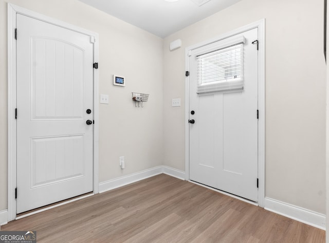 foyer entrance featuring baseboards and light wood-style floors