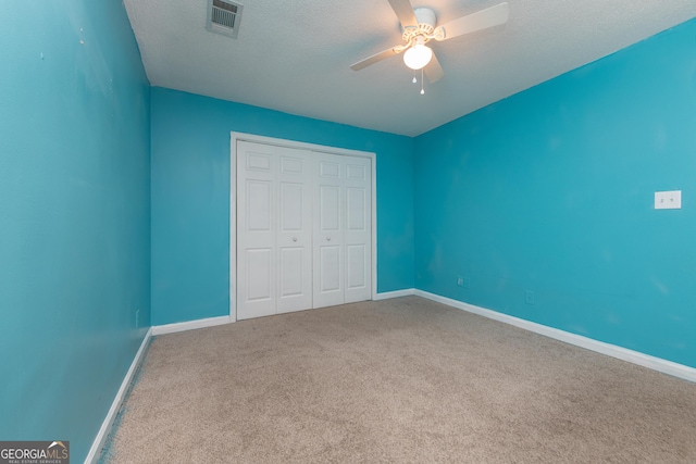 unfurnished bedroom featuring visible vents, carpet, baseboards, and a closet
