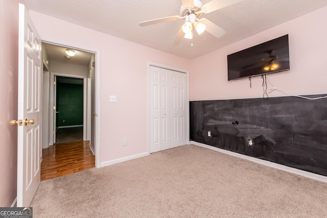 unfurnished bedroom with carpet flooring, ceiling fan, baseboards, and a closet