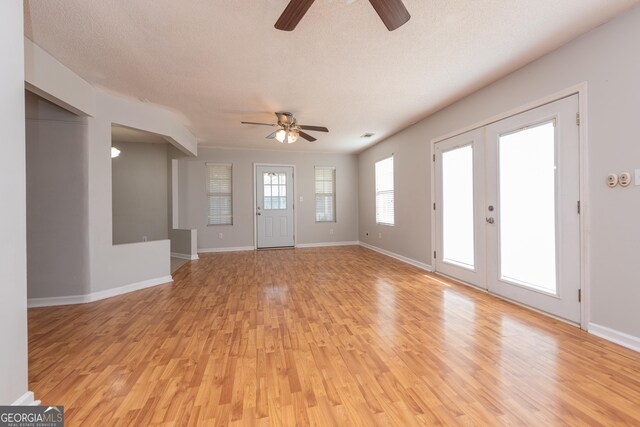foyer featuring baseboards, ceiling fan, french doors, and light wood finished floors