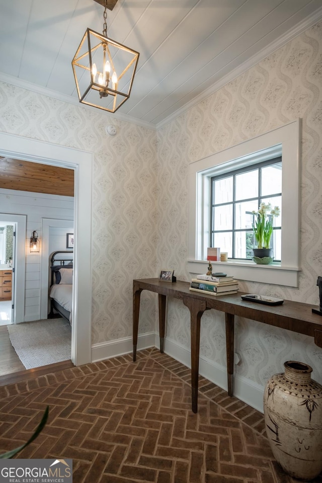 interior space featuring a chandelier, brick floor, baseboards, and ornamental molding