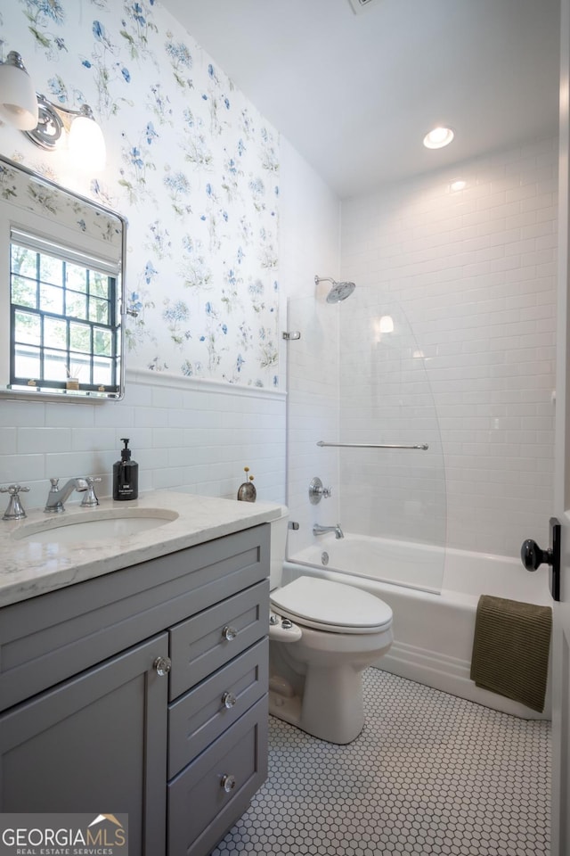 bathroom featuring wallpapered walls, wainscoting, toilet, shower / tub combination, and vanity