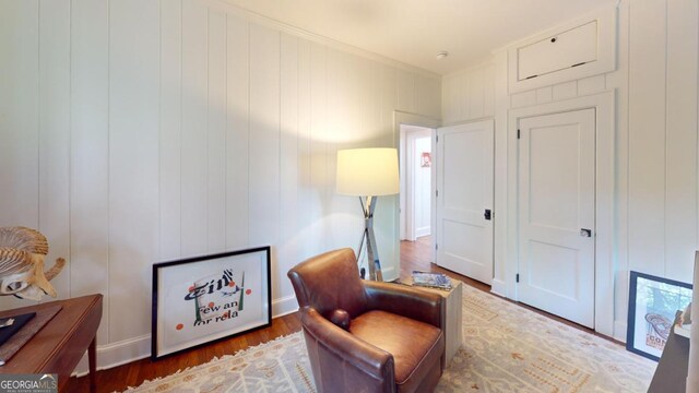 living area featuring wood finished floors and crown molding
