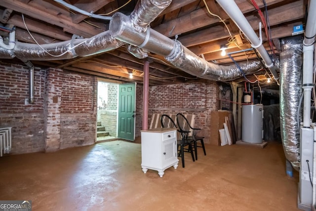 below grade area with gas water heater and brick wall
