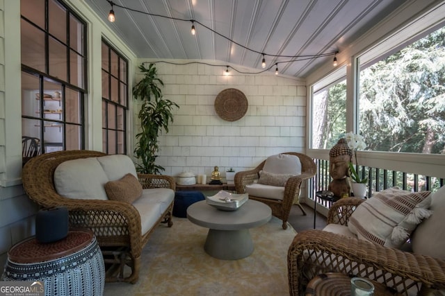 sunroom featuring outdoor lounge area and rail lighting