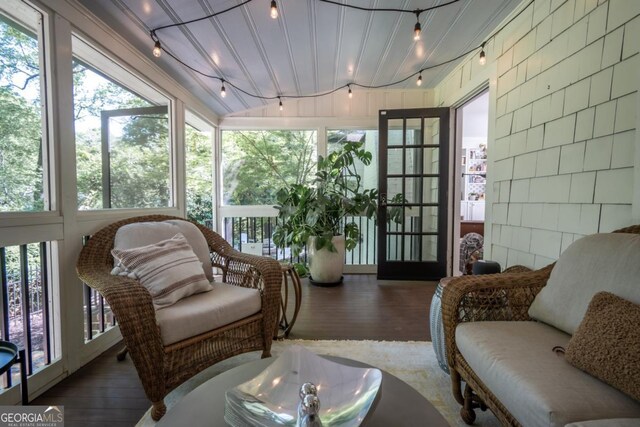 sunroom / solarium with wood finished floors and rail lighting