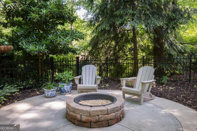 view of patio featuring an outdoor fire pit and fence