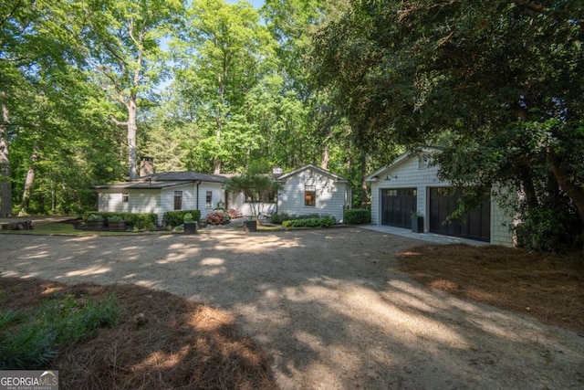 view of front of home with an outbuilding, a garage, and dirt driveway