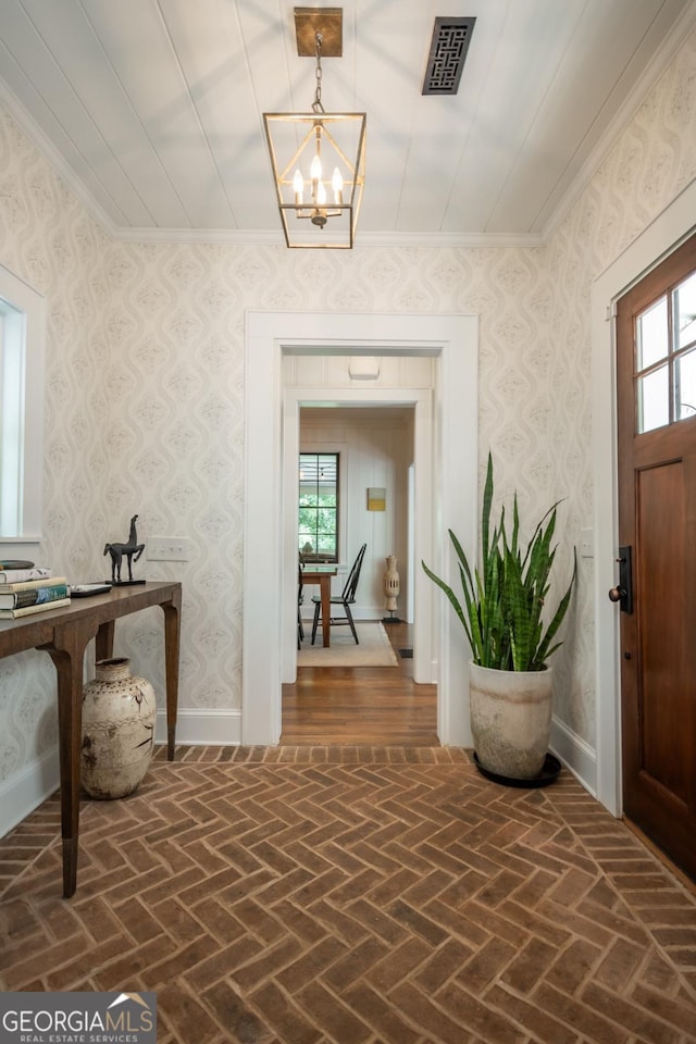 entryway with a chandelier, visible vents, brick floor, and a wealth of natural light