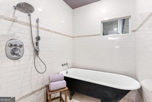 full bath featuring a tile shower, a freestanding bath, and tile walls