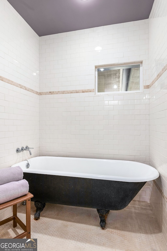 bathroom with tile walls and a freestanding tub