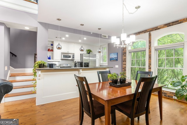 dining space featuring a wealth of natural light, visible vents, an inviting chandelier, and light wood-style floors