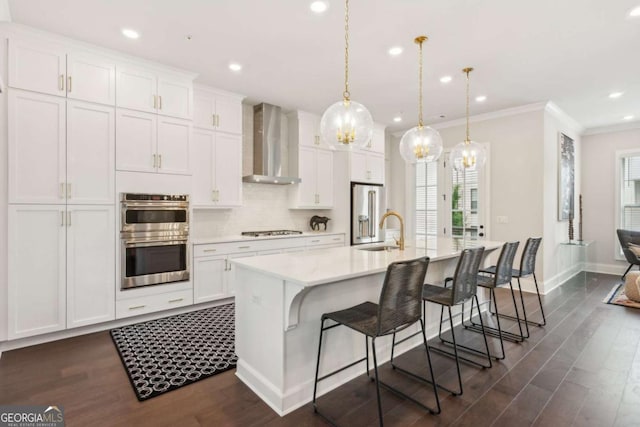 427 Burton Dr Unit 427, Alpharetta, GA 30009 - kitchen with wall chimney range hood, appliances with stainless steel finishes, a large island, light countertops, and dark wood finished floors