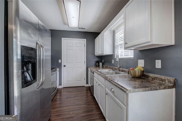 50 Westside Chase, Cartersville, GA 30120 - kitchen with dark wood finished floors, stainless steel appliances, dark countertops, a sink, and white cabinetry
