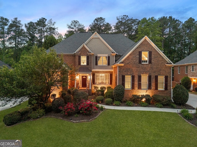 view of front facade featuring a lawn and brick siding