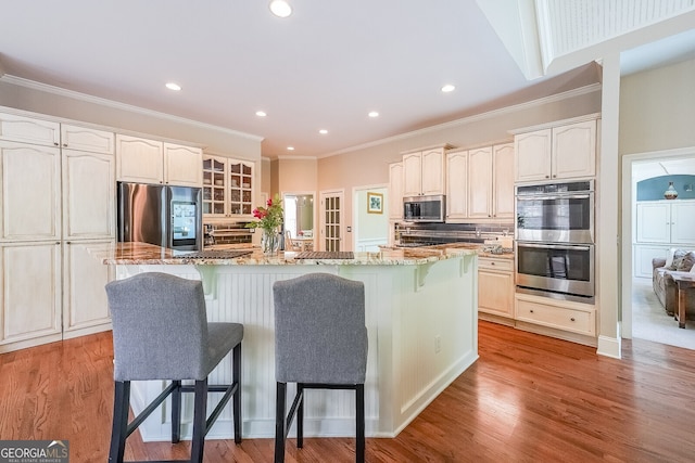 kitchen featuring light stone countertops, stainless steel appliances, and a kitchen breakfast bar