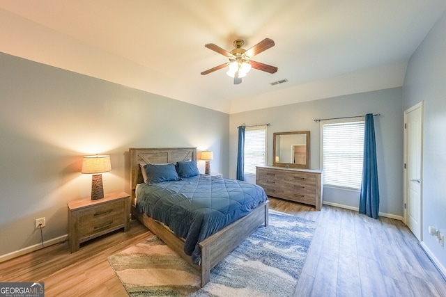 bedroom with wood finished floors, visible vents, baseboards, and ceiling fan