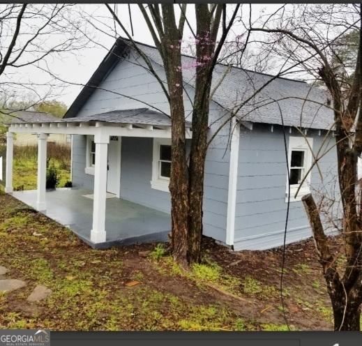 1323 S Hairston Rd, Stone Mountain, GA 30088 - view of home's exterior featuring a porch and roof with shingles