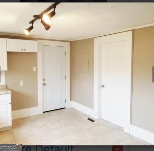 1323 S Hairston Rd, Stone Mountain, GA 30088 - kitchen featuring baseboards, white cabinetry, and light countertops
