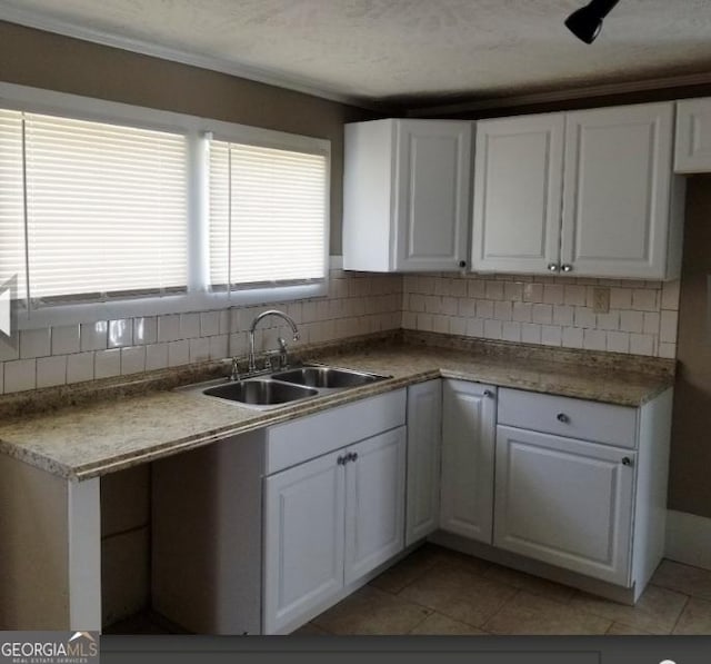 1323 S Hairston Rd, Stone Mountain, GA 30088 - kitchen with white cabinets, tasteful backsplash, a sink, and light tile patterned flooring