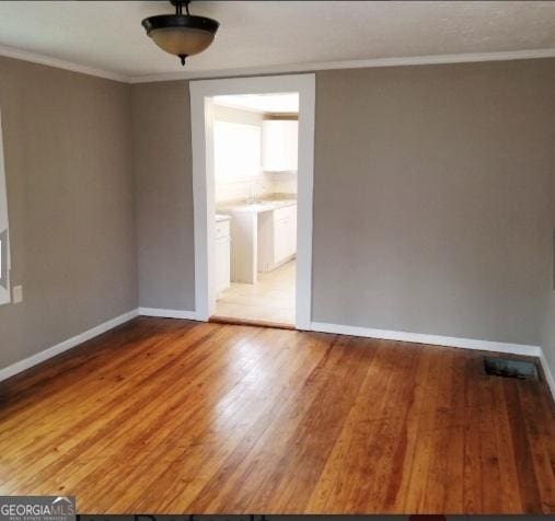 1323 S Hairston Rd, Stone Mountain, GA 30088 - empty room with baseboards, crown molding, and wood finished floors