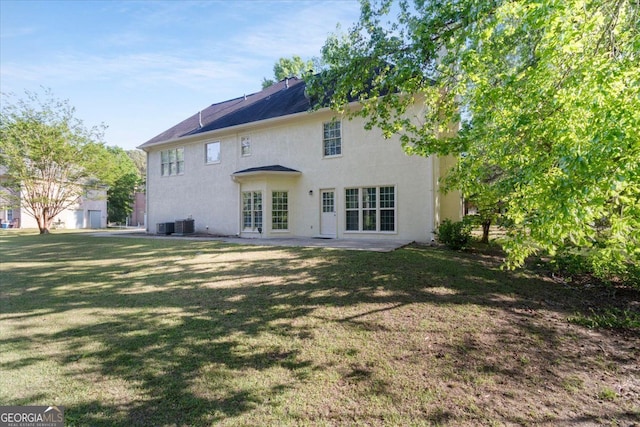 back of house featuring stucco siding, a yard, cooling unit, and a patio