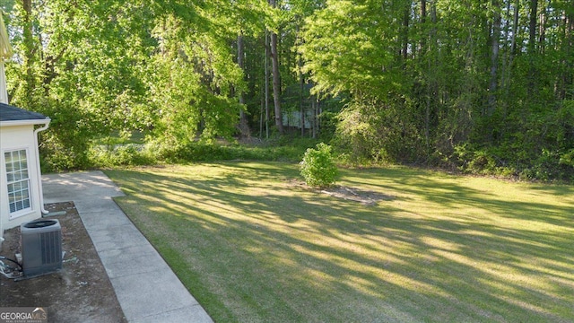 view of green lawn with central AC