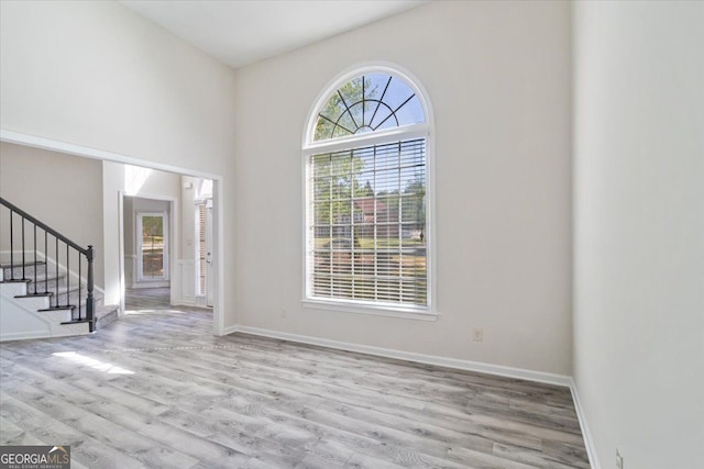 entryway featuring stairs, wood finished floors, and baseboards