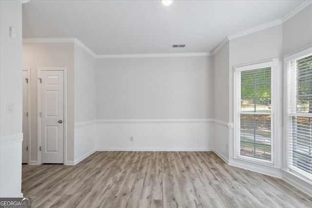 unfurnished room featuring wood finished floors, crown molding, and baseboards