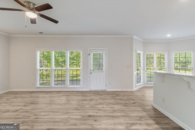 unfurnished living room featuring baseboards, healthy amount of natural light, recessed lighting, and crown molding