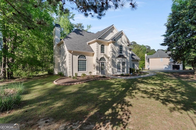 view of front facade with a chimney and a front lawn