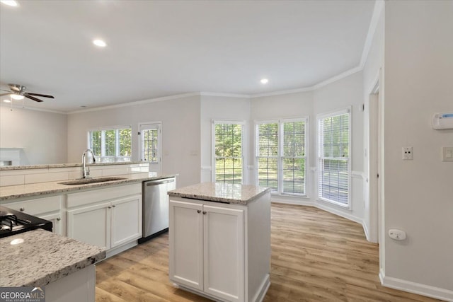 kitchen featuring a sink, stainless steel dishwasher, crown molding, ceiling fan, and white cabinets