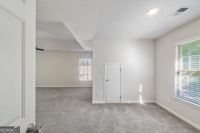 spare room featuring carpet floors and baseboards